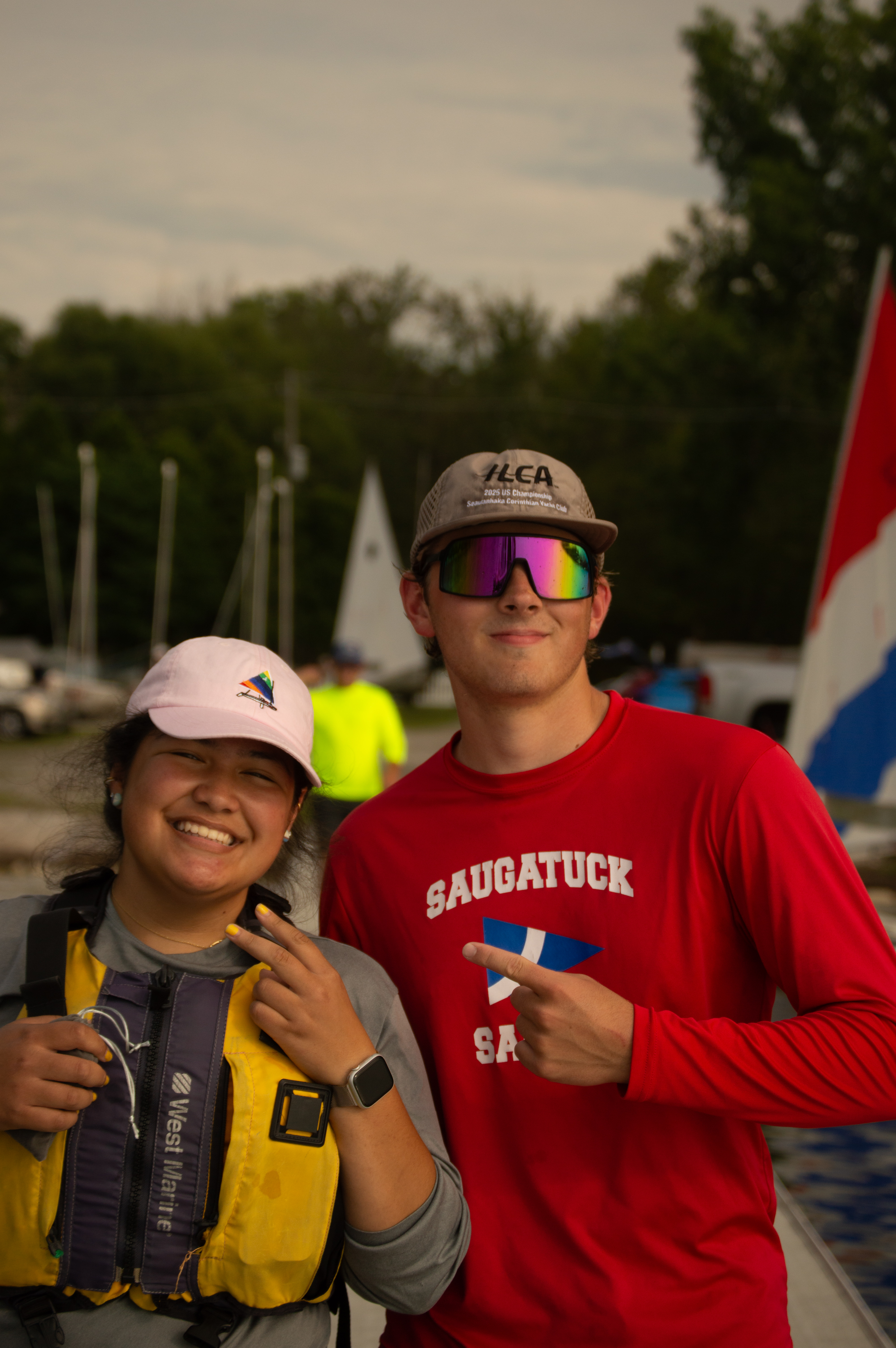 Two people pose for a photo on the dock at the MSU Sailing Center on Lake Lansing