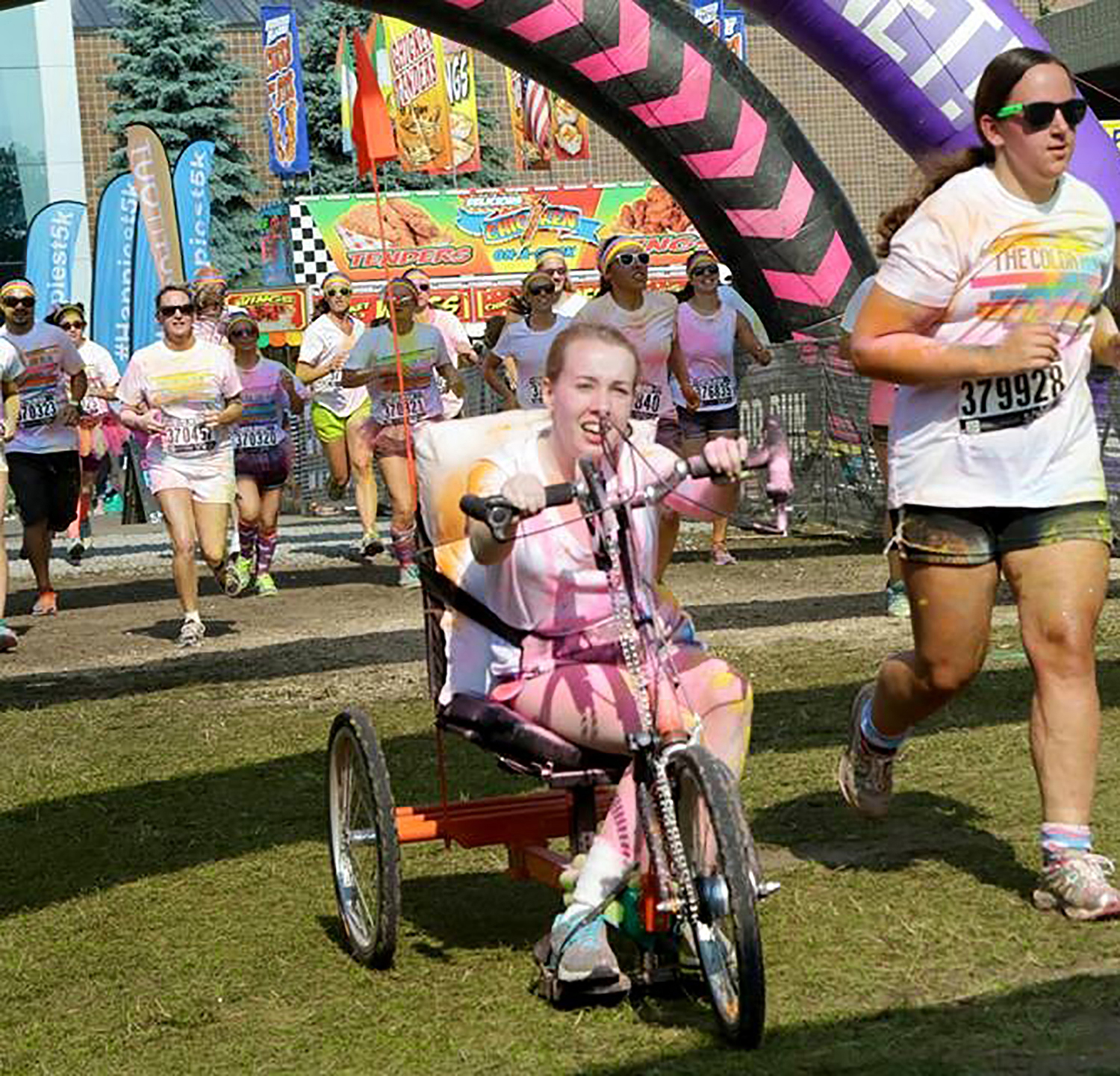 Girl on hand cycle passing the finish line