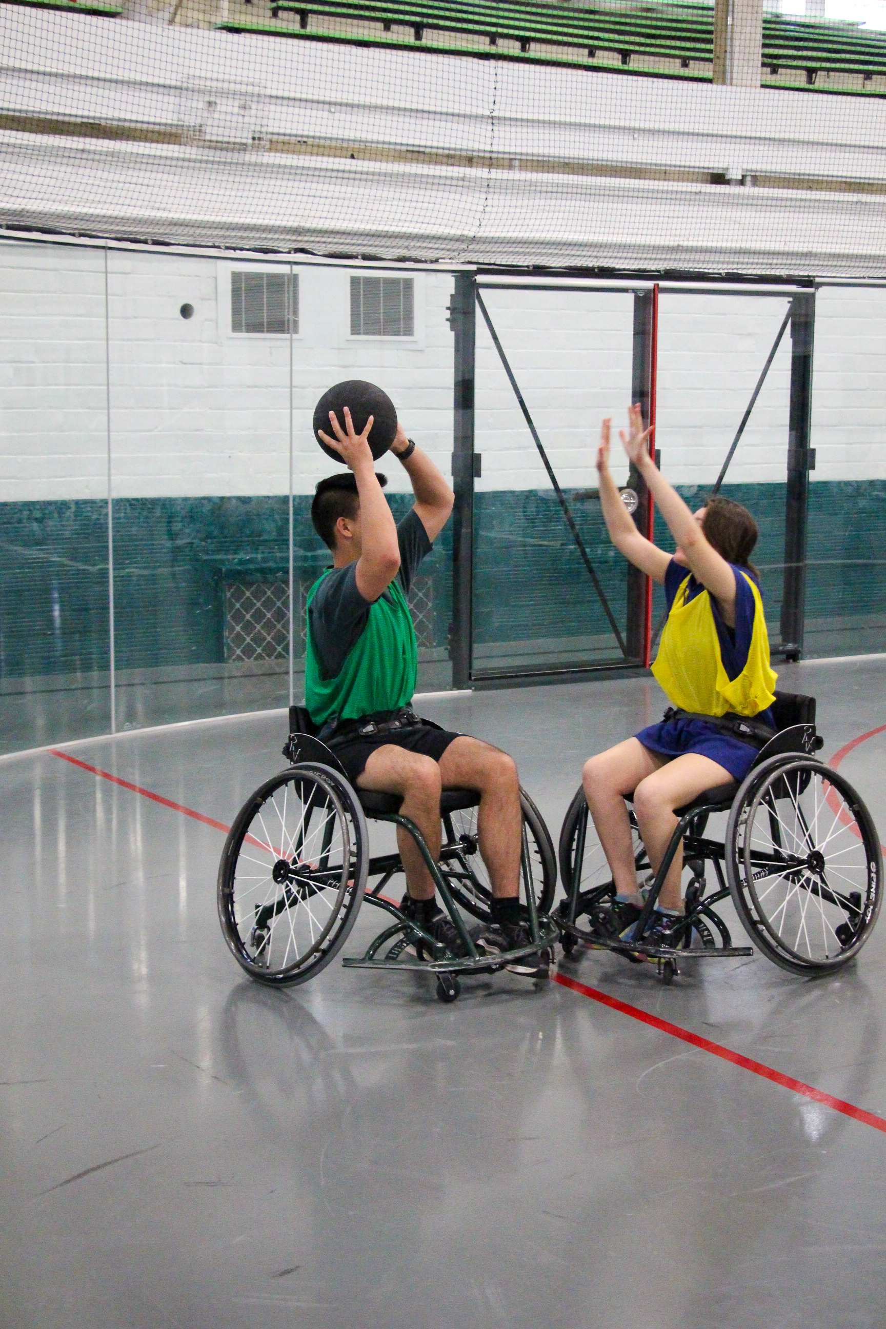 Two people in wheelchairs playing trashketball