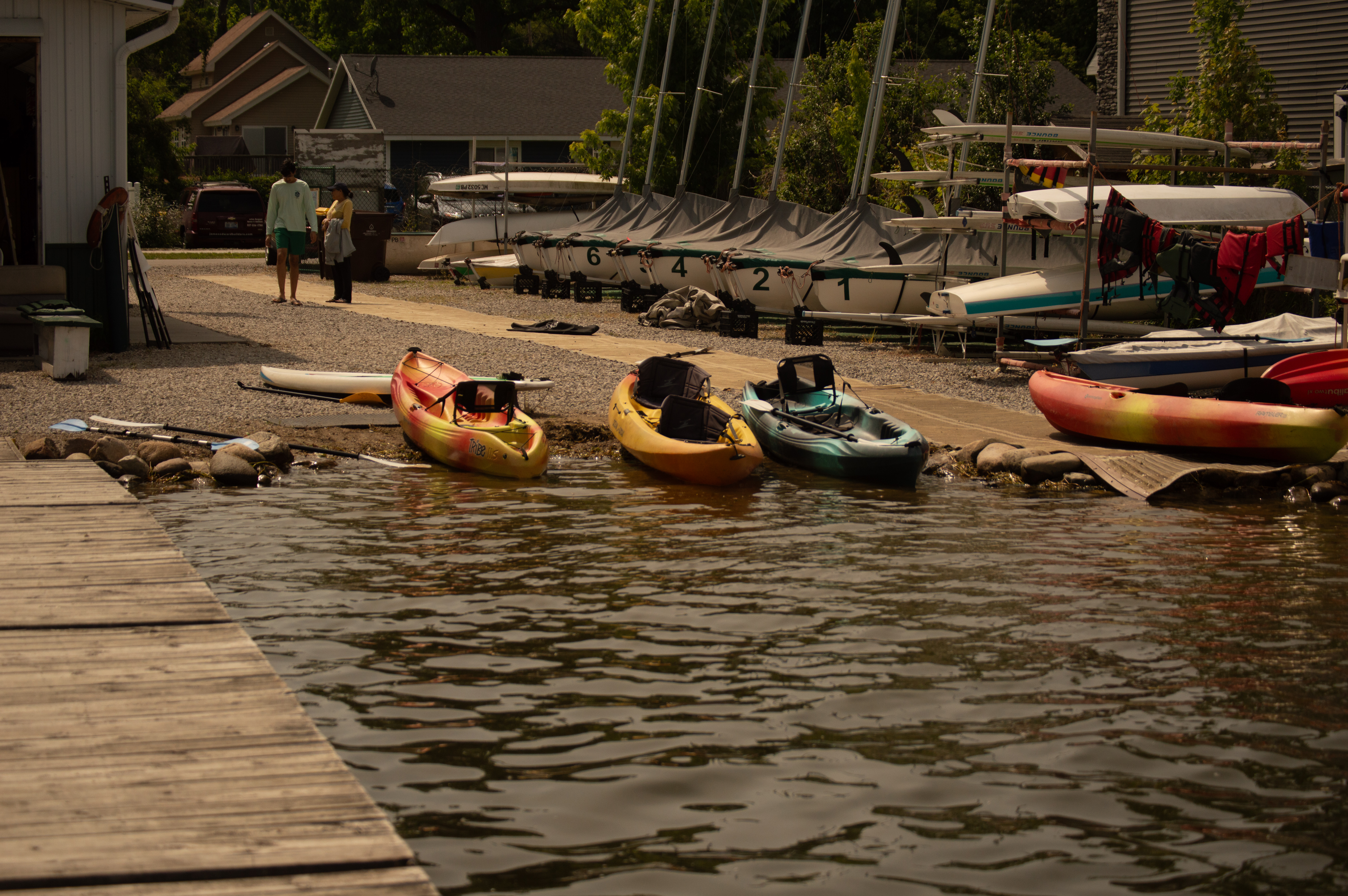 Kayaks lined up on the water's edge at the MSU Sailing Center