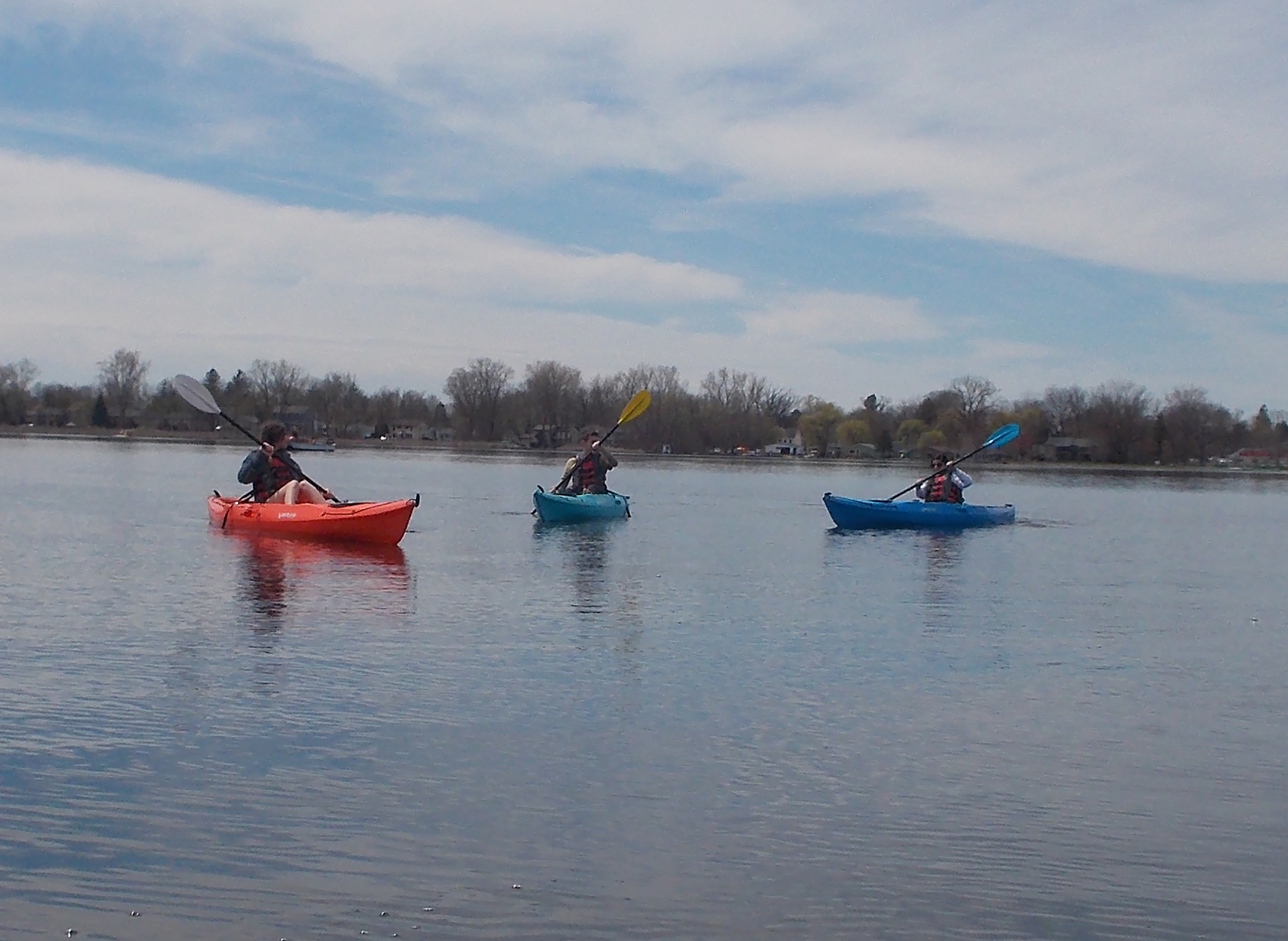 3 people on single people kayaks on Lake Lansing 